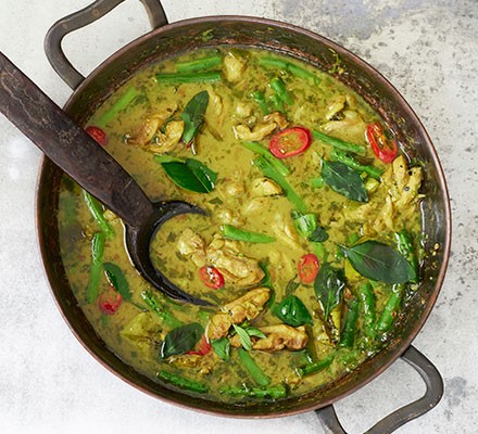 Chef preparing colorful Thai curry with fresh vegetables